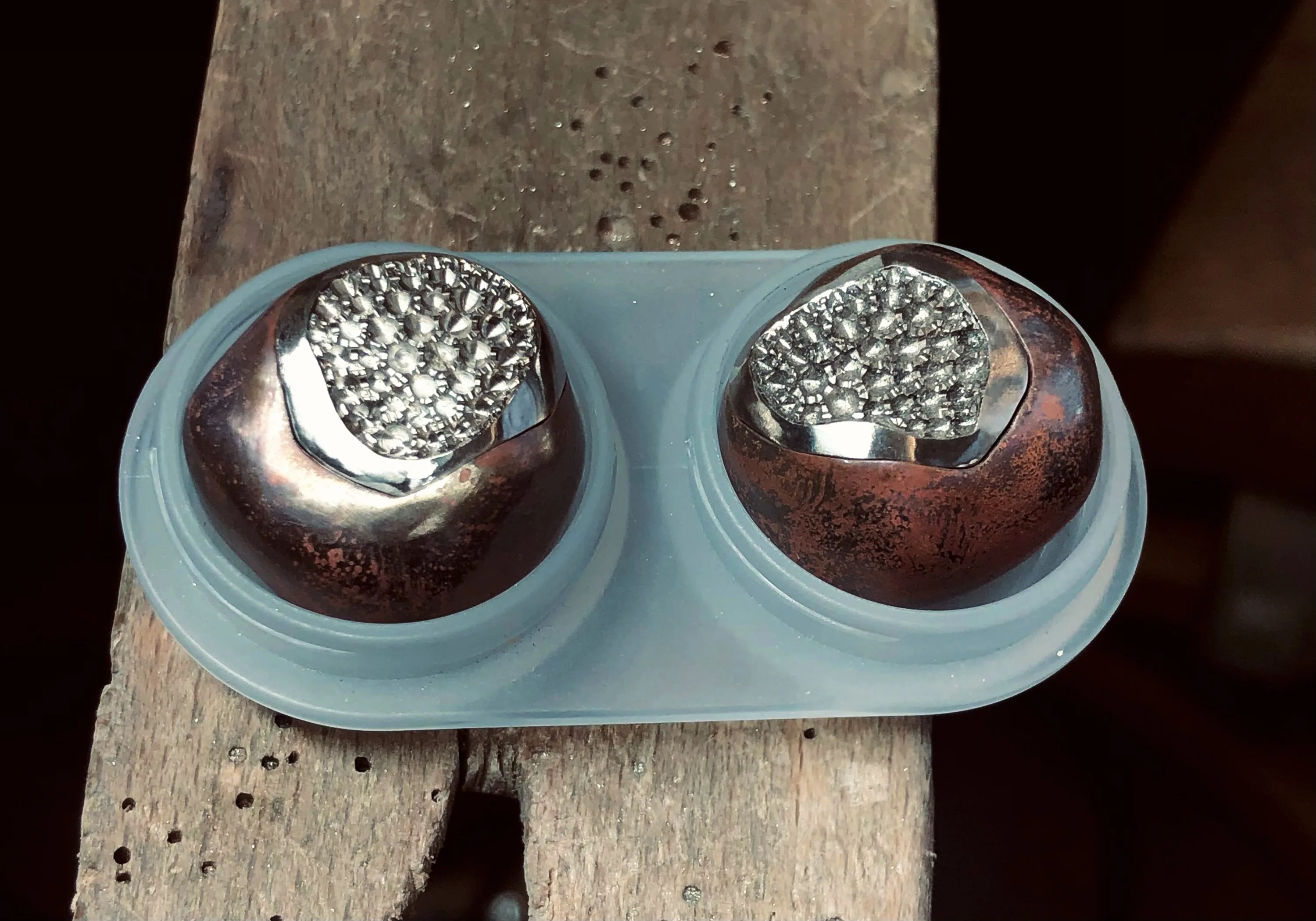 Two bronze chestnut replicas with gold white spots, seamlessly fitting into the bronze outer shells.
