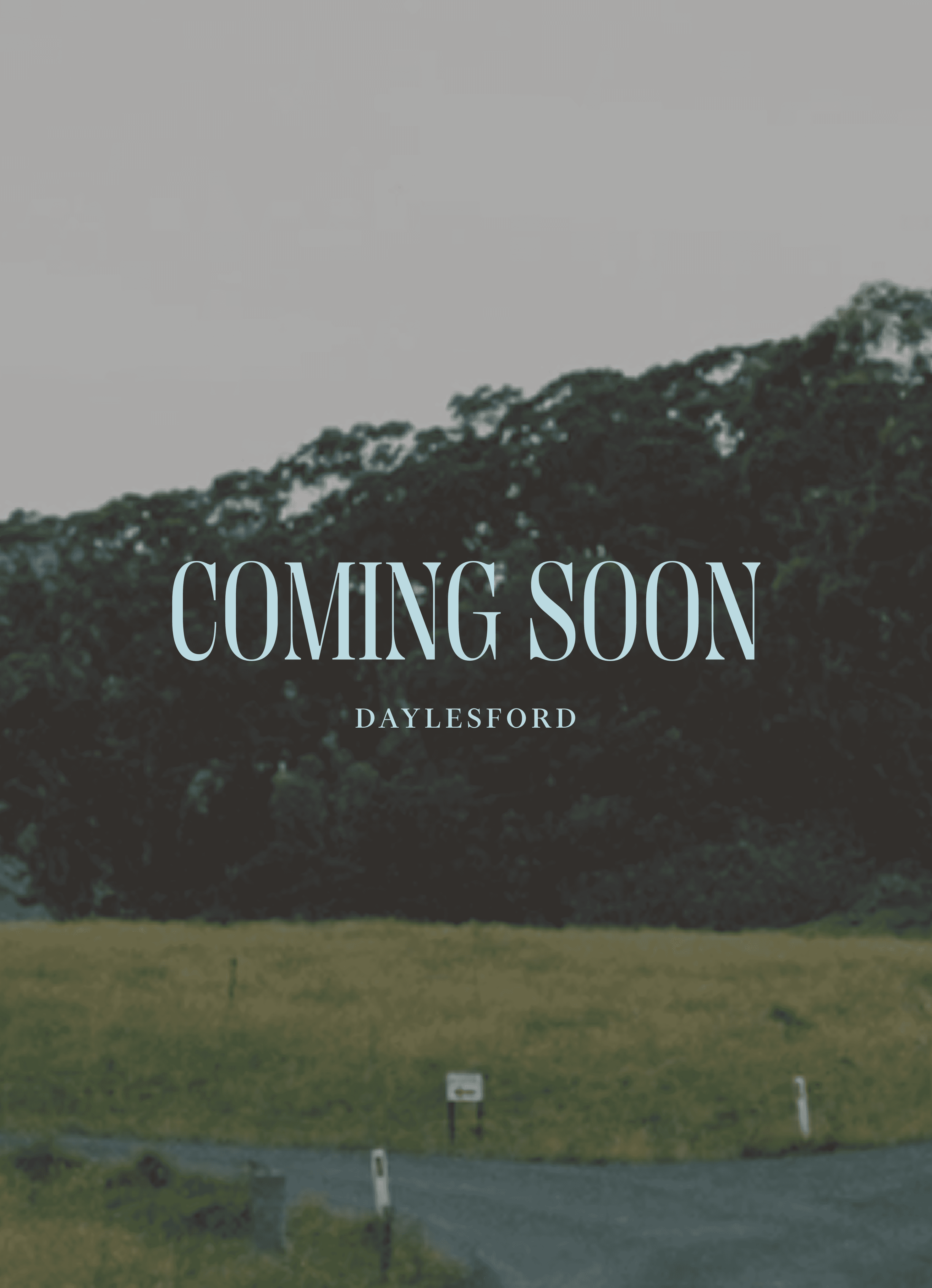 gray asphalt road between green grass field during daytime