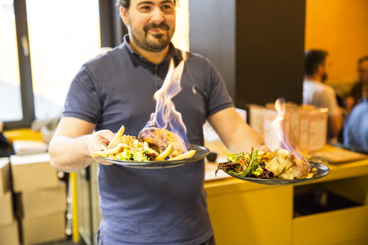 Poulet rôti avec une flamme accompagné de frites au gras de boeuf et d'un verre de vin rouge dans un restaurant