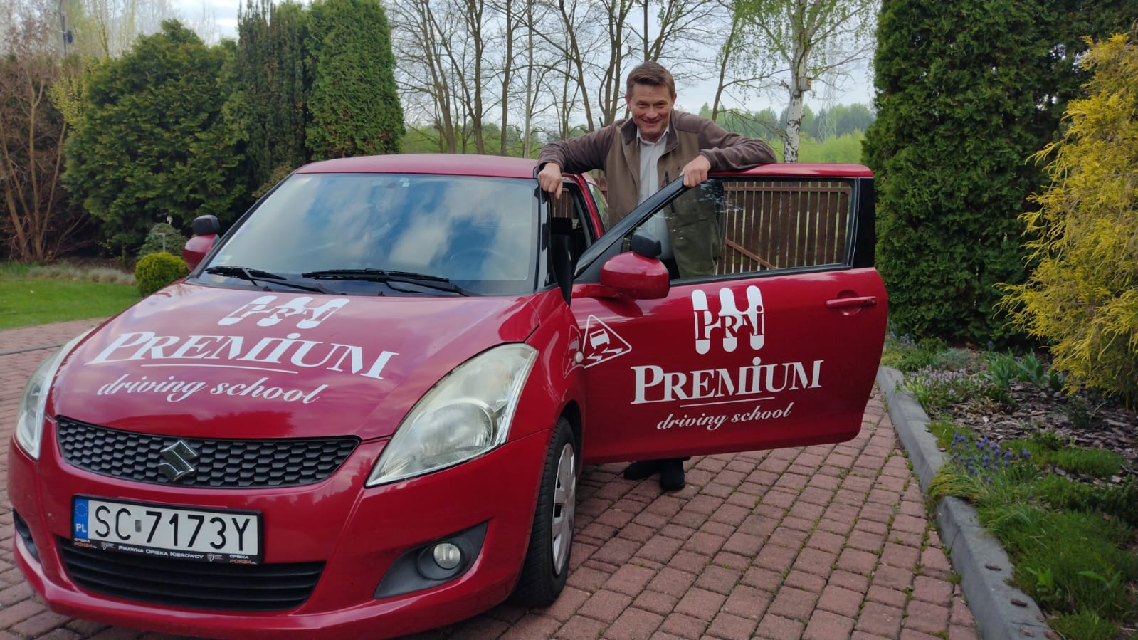 Robert Bissinger – Instruktor wychodzący z czerwonego auta szkoleniowego Premium.