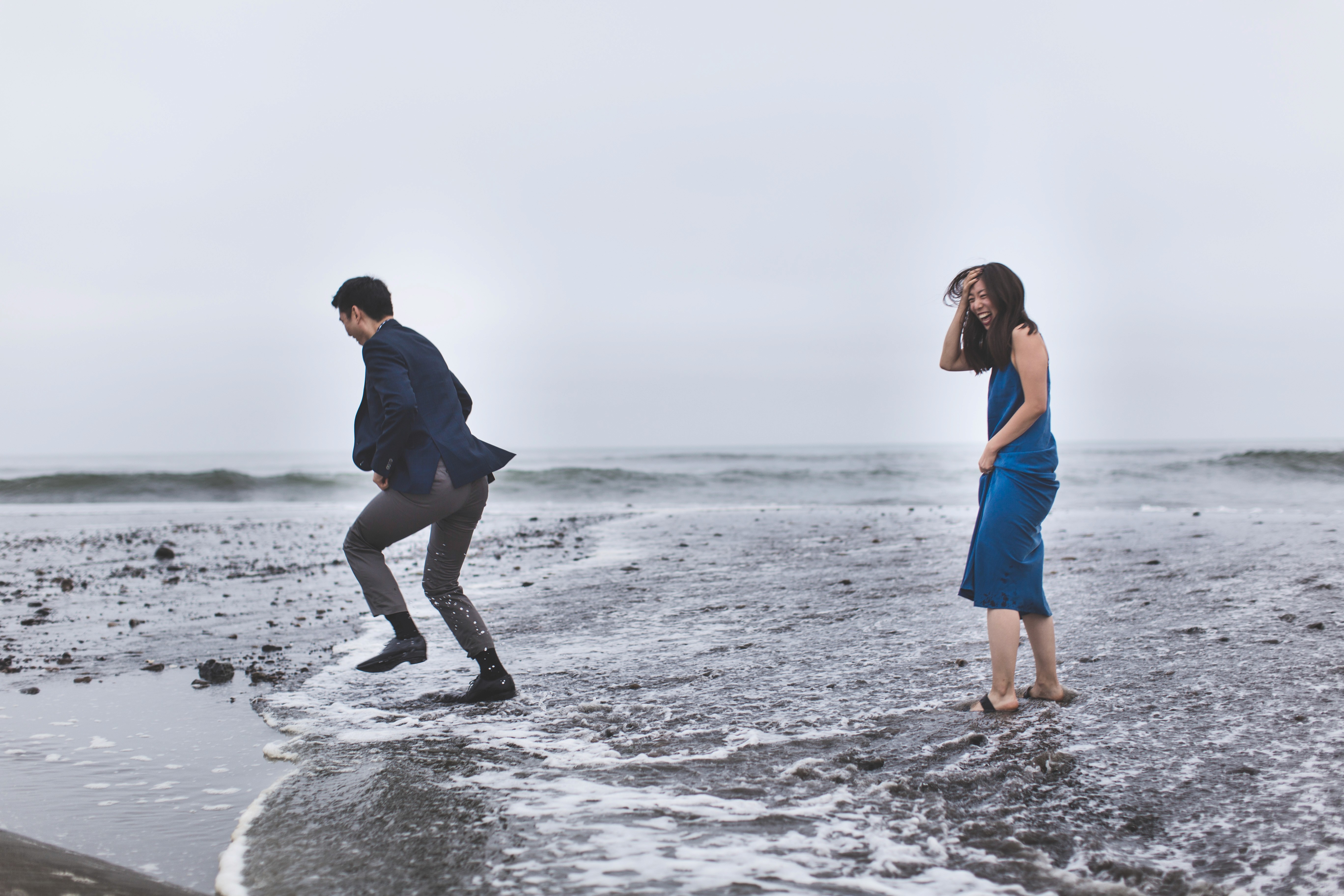 Couple running from small waves