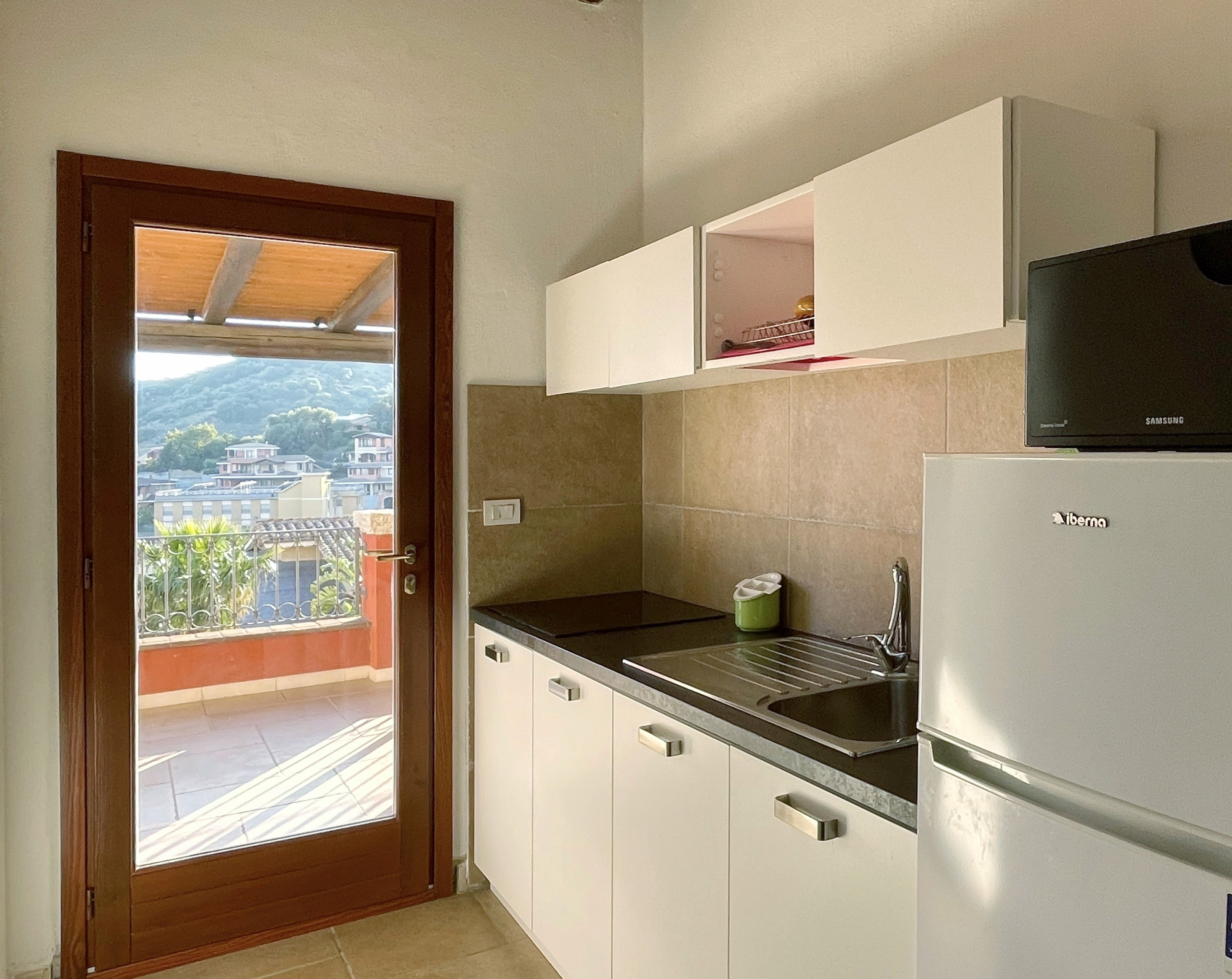 Cucina di La Peonia con porta finestra e affaccio esterno