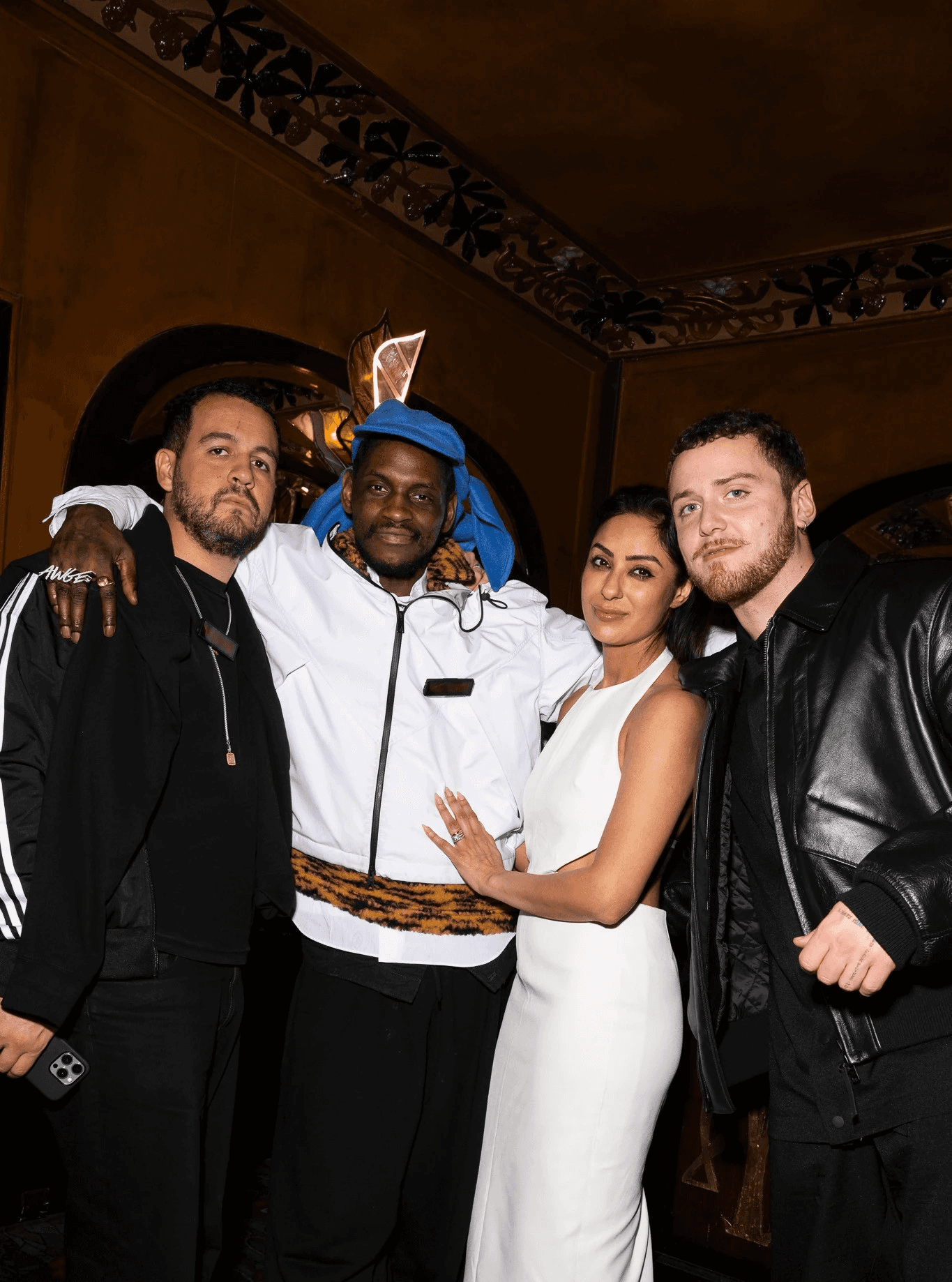 Dancer in black outfit with arms raised, arching backwards