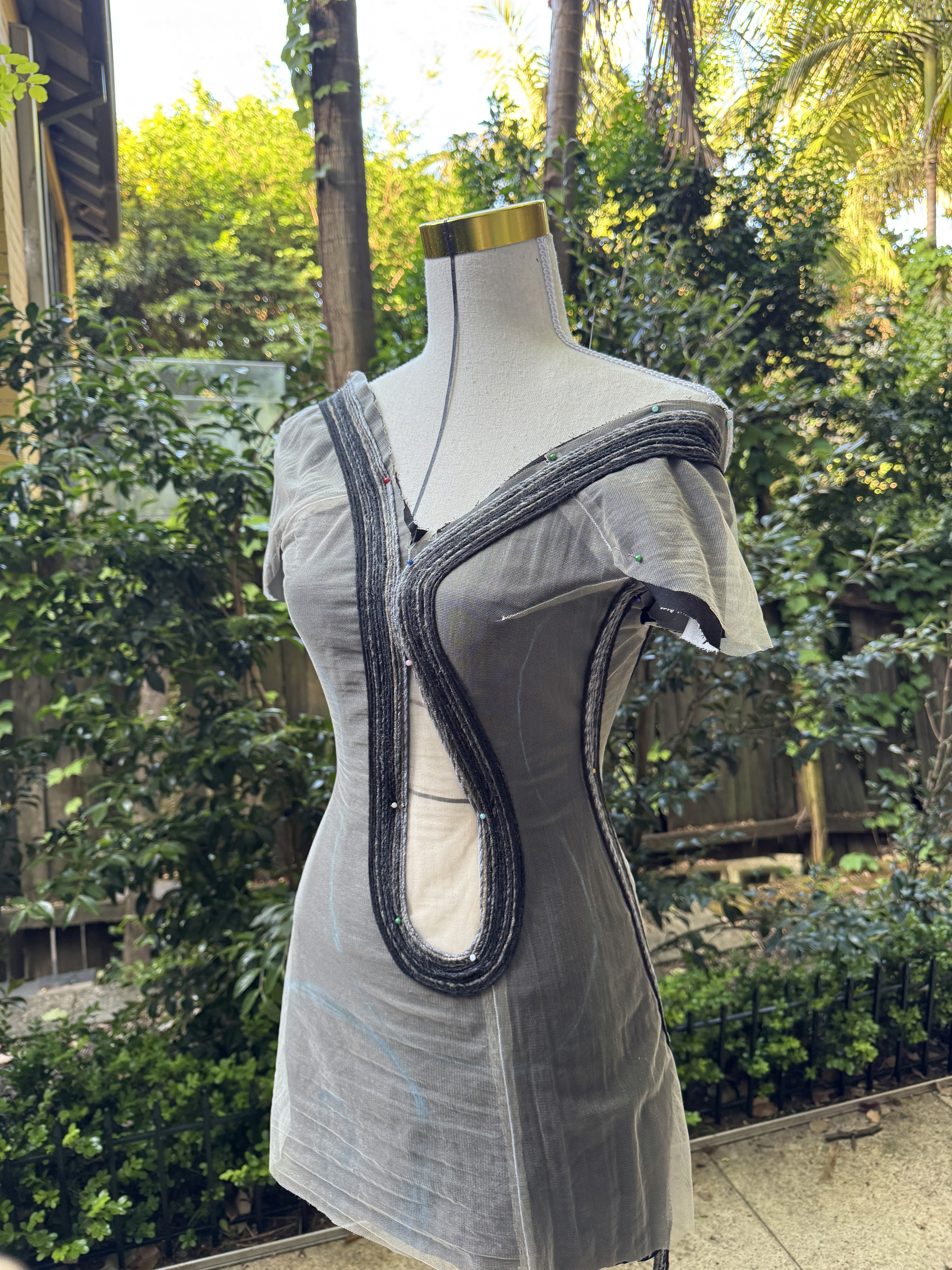 Close-up of beaded bodice with plunging V neckline, sculptural draped beadwork, and central oval cut-out detailing