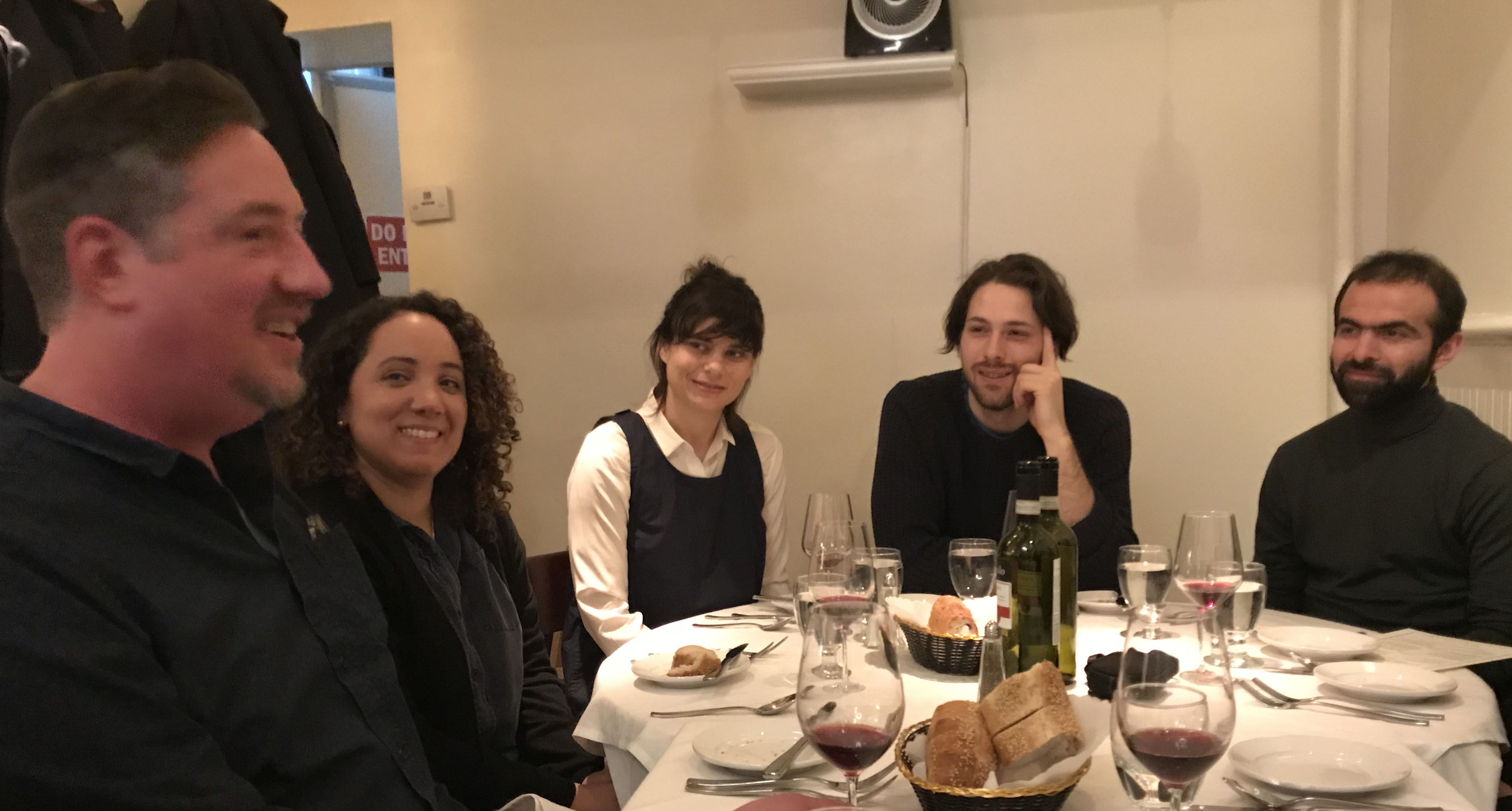 A photo of a group of people sitting at a dinner table.