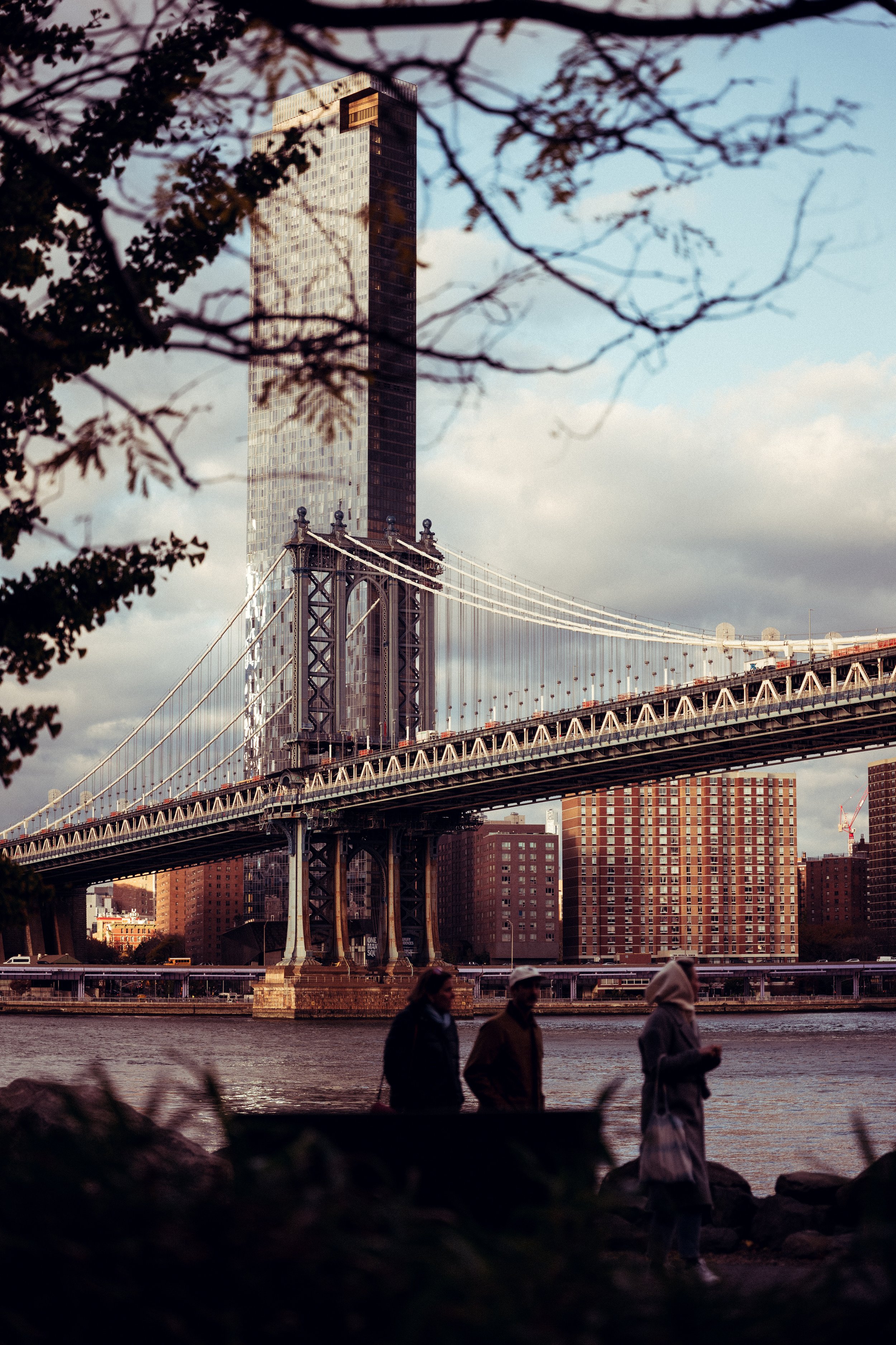 Black and white image of people working at a table with laptops, showing hands gesturing during discussion of digital content displayed on screens, with fabrica® logo in the corner.