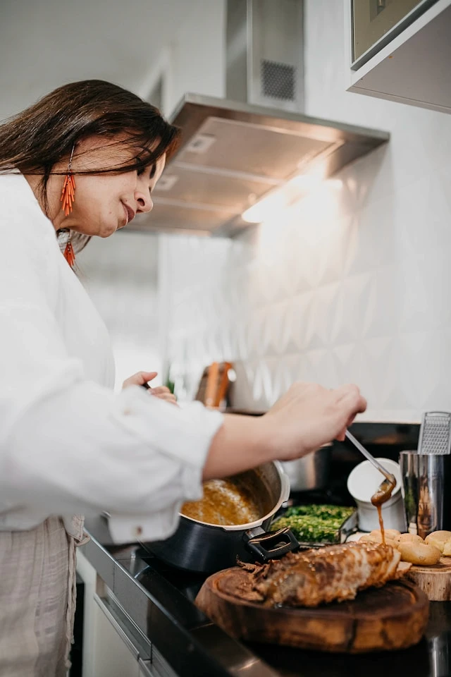 Woman looking downward in a softly lit kitchen