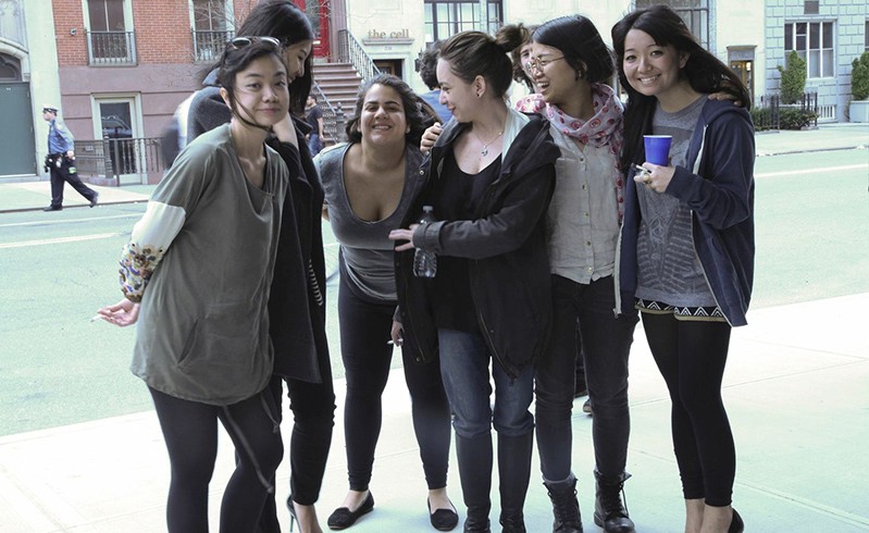 portrait of girl students having fun on the sidewalk