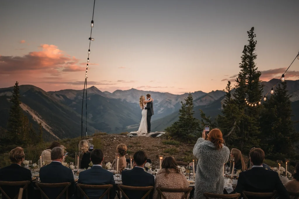 Bride and groom share their first dance at a mountaintop Vail Colorado wedding at sunset, surrounded by guests at an outdoor reception, photographed by Summit Photo and Film.