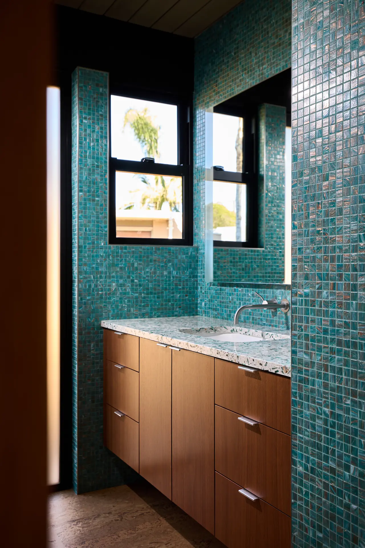 Portrait of the guest bathroom vanity, featuring a modern design that complements the Eichler home's historical charm. Photo by Todd Huge.