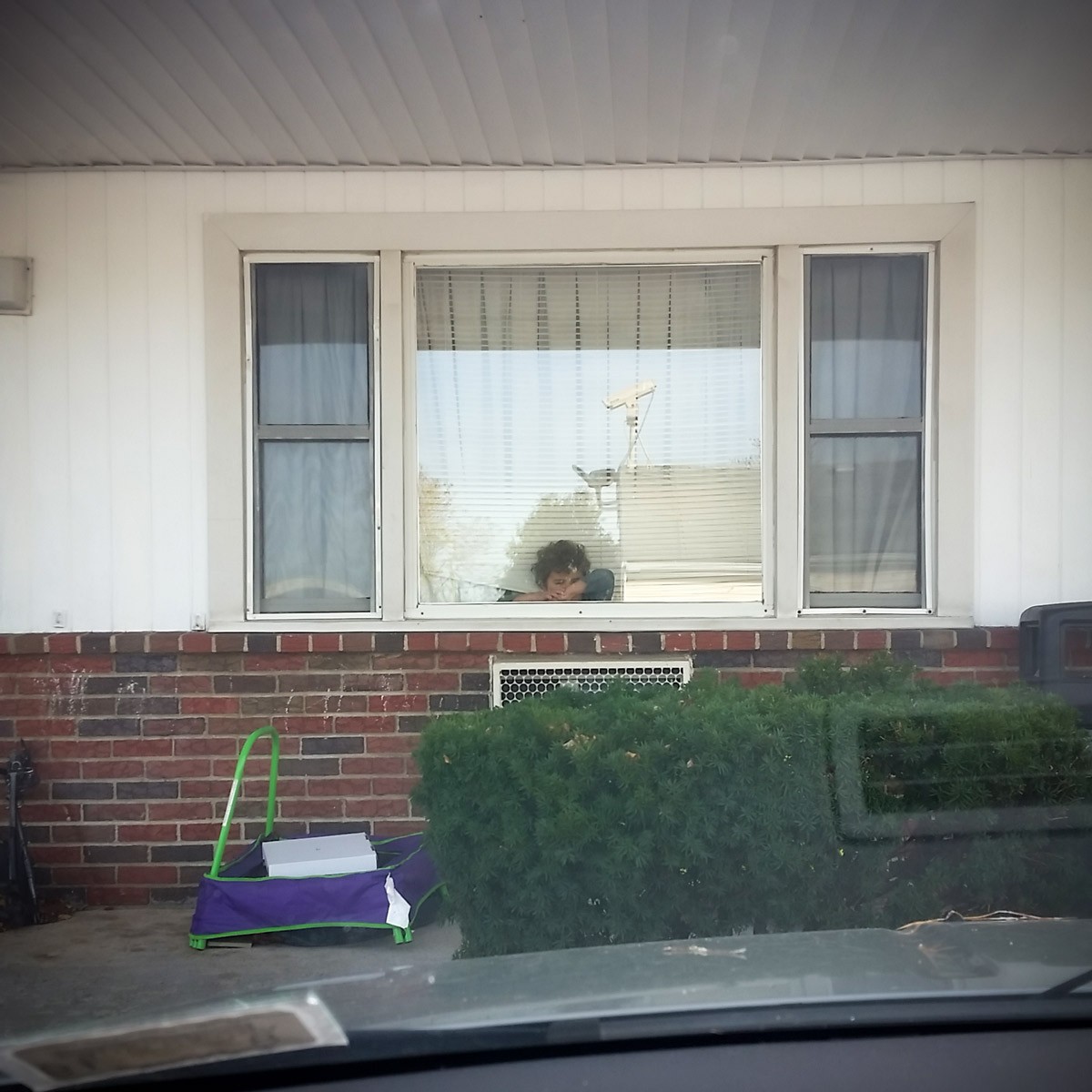 An asylum seeker child looks out the window