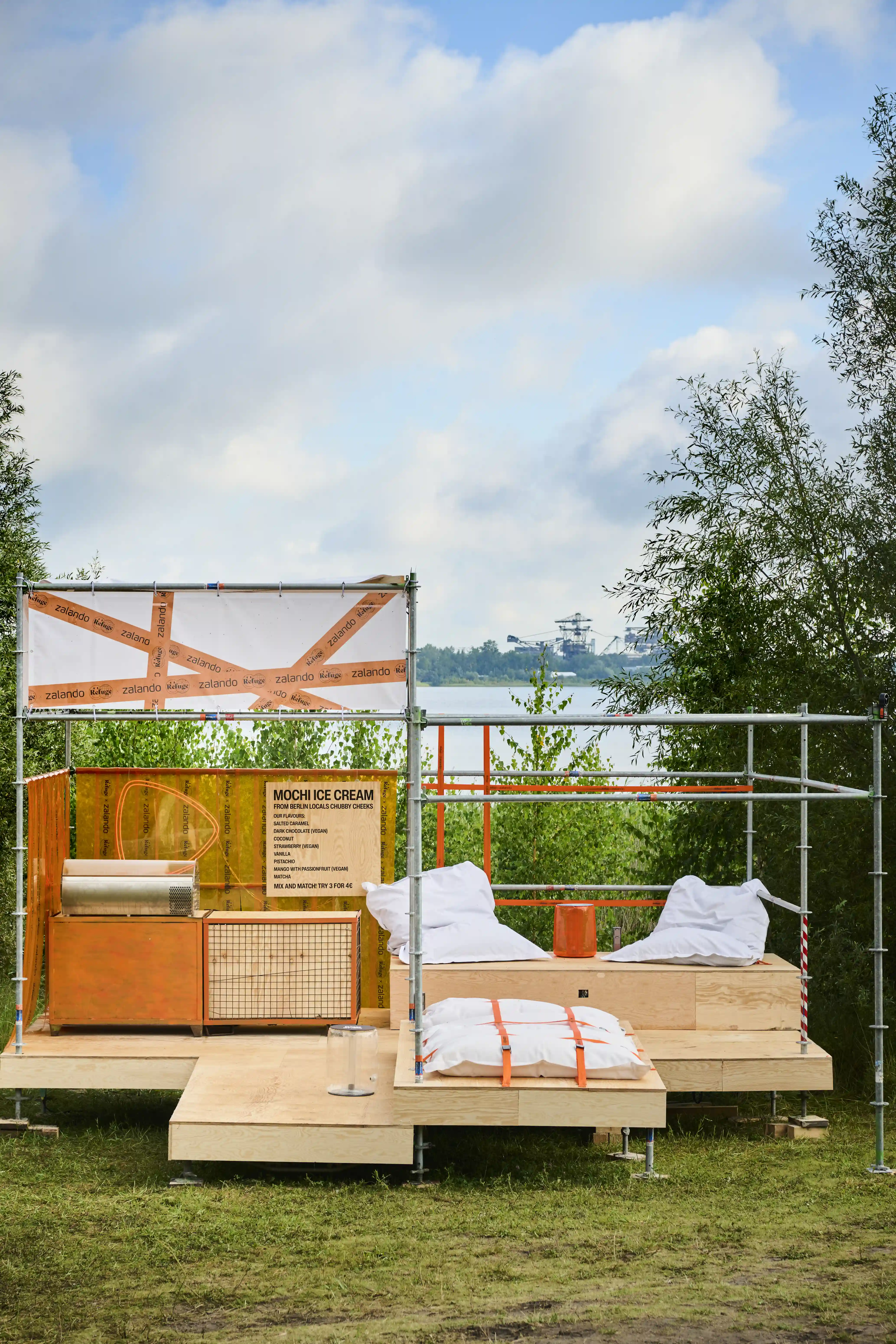 Scaffold platform with mochi ice cream counter and pillow loungers overlooking the lake.