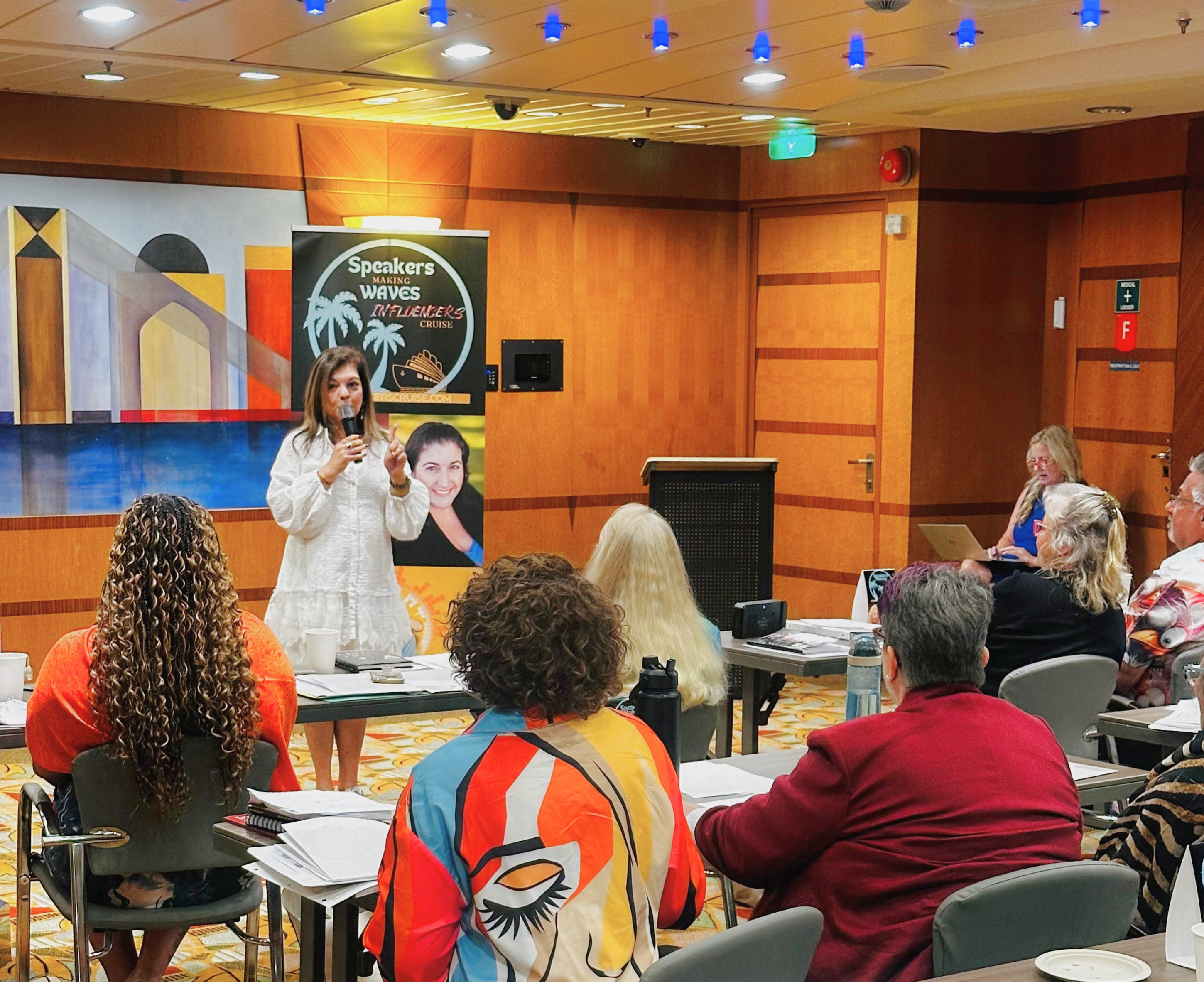 Shairose Gulamani with other Speakers on Influencers Cruise 2026. Speaker giving a keynote to people in a conference room.