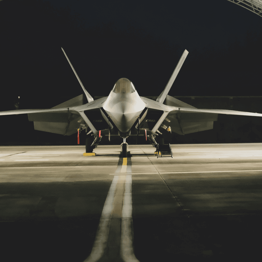 Snow-capped mountain peak behind evergreen trees at sunrise.