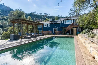Hillside home with a swimming pool and pergola