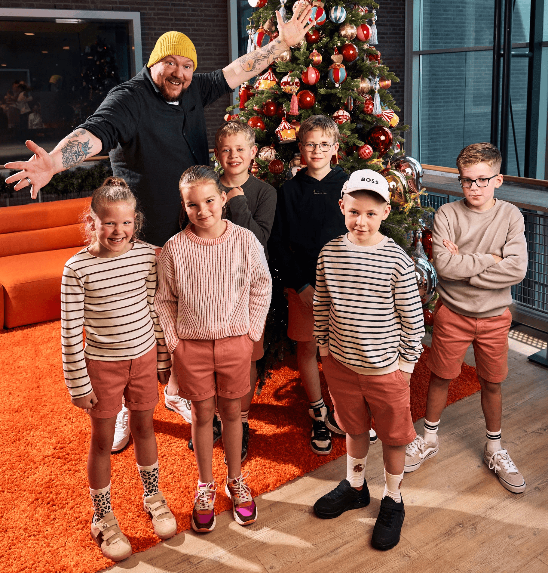 Kinderen in korte broek bij de kerstboom