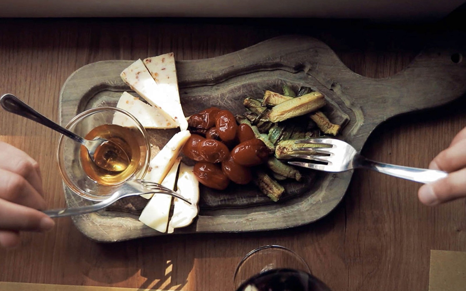 Ost, tomater og zucchini på et trebrett under en toskansk vintur-smaking.