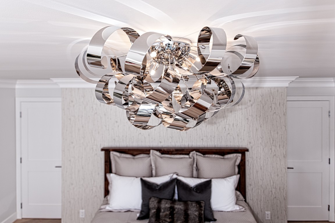 Image of Modern chandelier in a KHD Homes designed primary suite with luxurious furniture and window coverings.