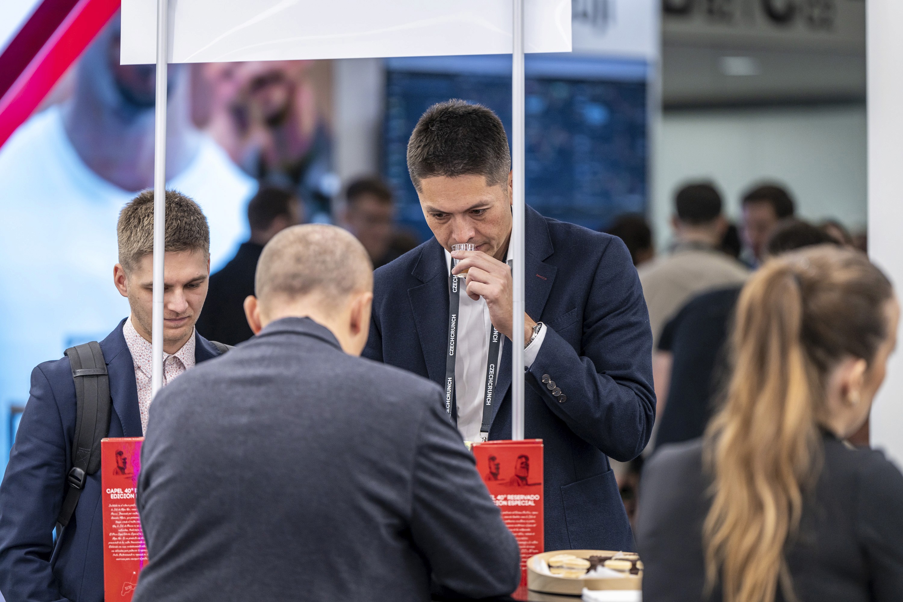 Attendees sampling products at a sponsor booth during a conference exhibition.