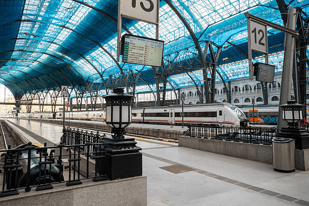 Modern Spanish train station with travelers and departure boards
