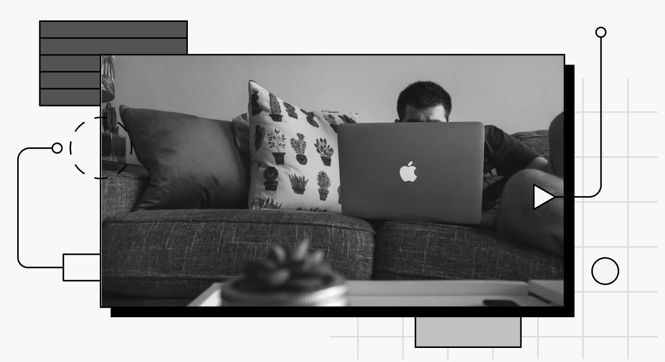 A person looking at a laptop while lying on a couch.