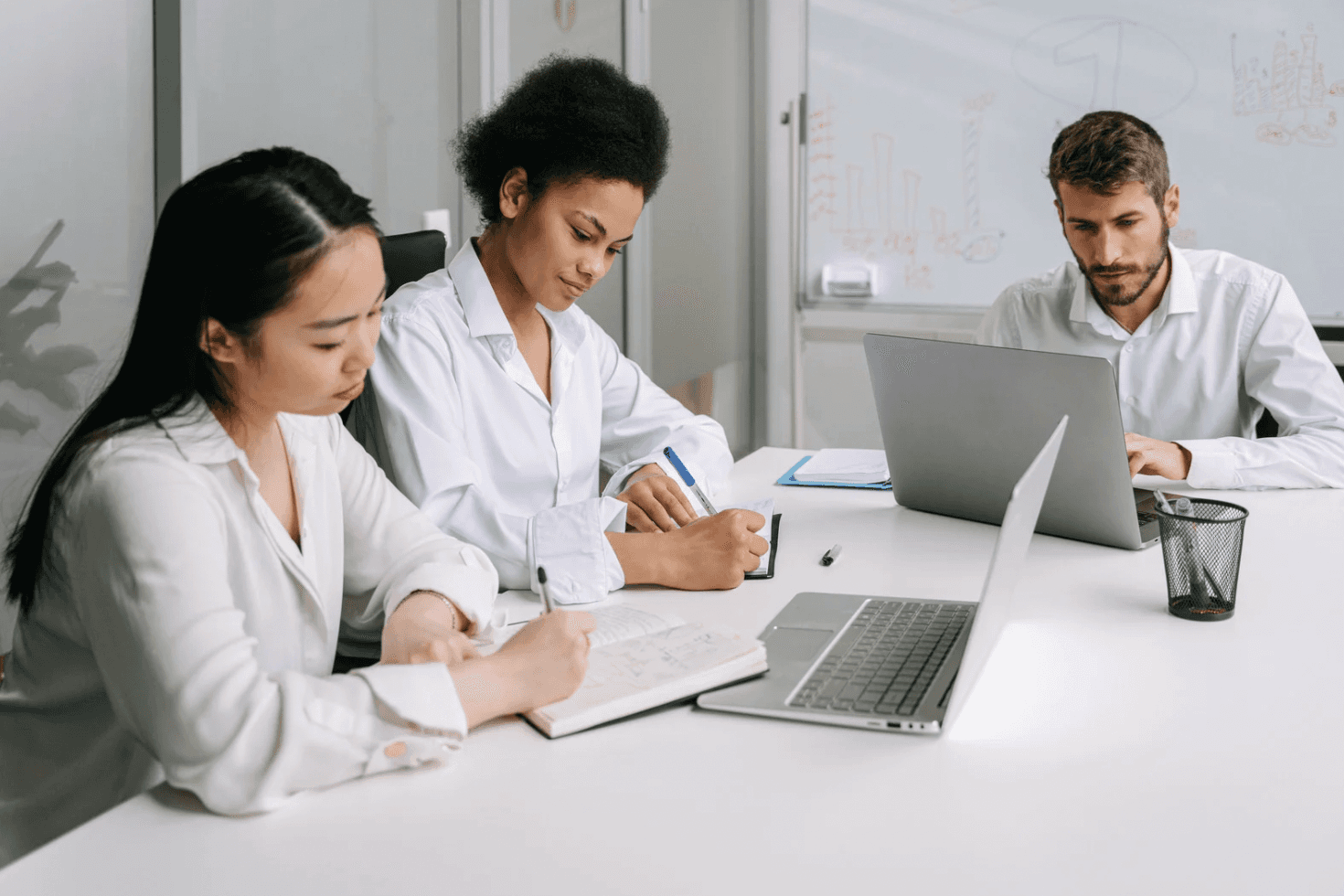 Team working at a conference table with laptops and notes, highlighting the complexity of managing hundreds of Amazon PPC campaigns at scale.