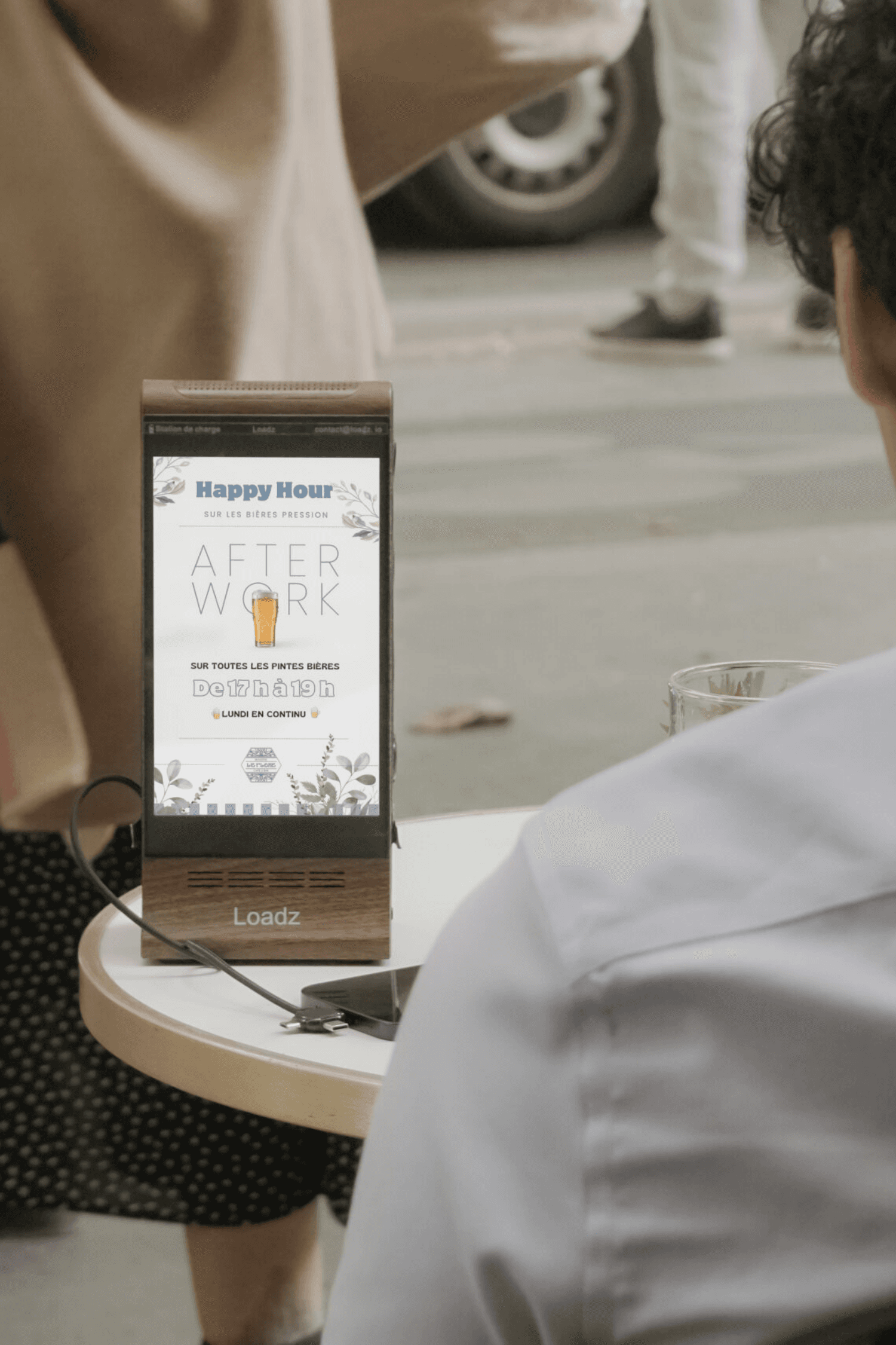 Person in a dark shirton a phone call, seated at a desk with papers, exudes a thoughtful, focused demeanor. Background shows dark horizontal blinds.