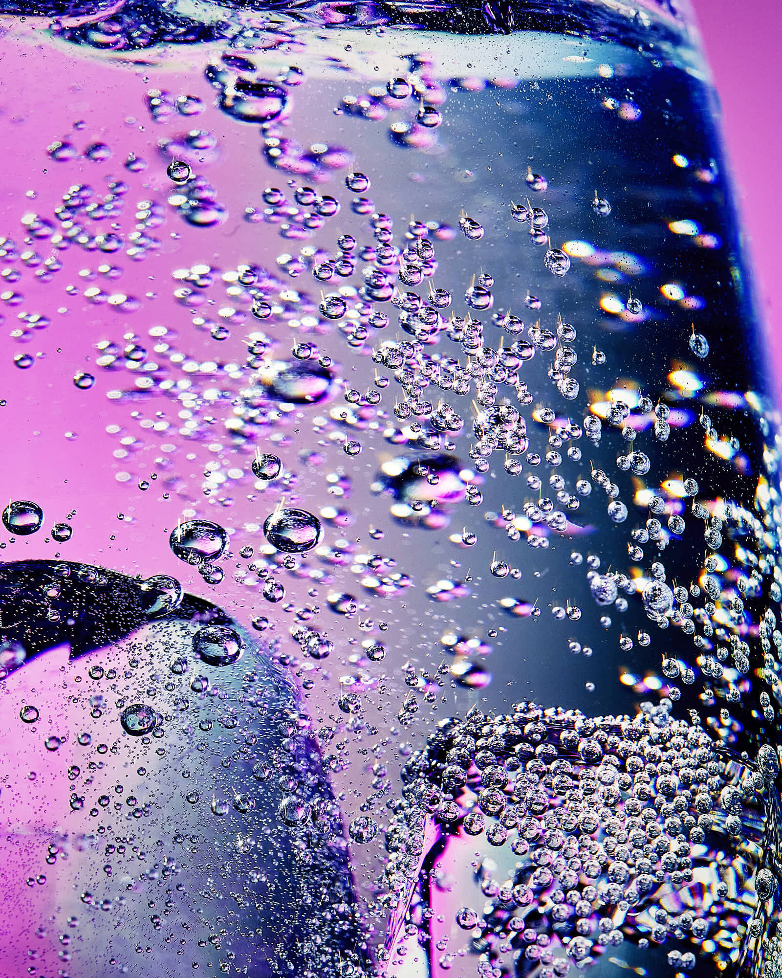 Close-up of a textured surface with vibrant pink and blue hues, featuring bubbles and intricate patterns.