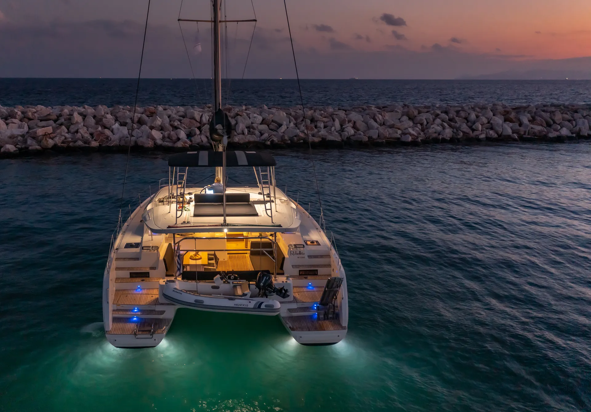 White Rock 36 speedboat with captain at helm cruising calm blue waters near Paros coastline with hills in background.