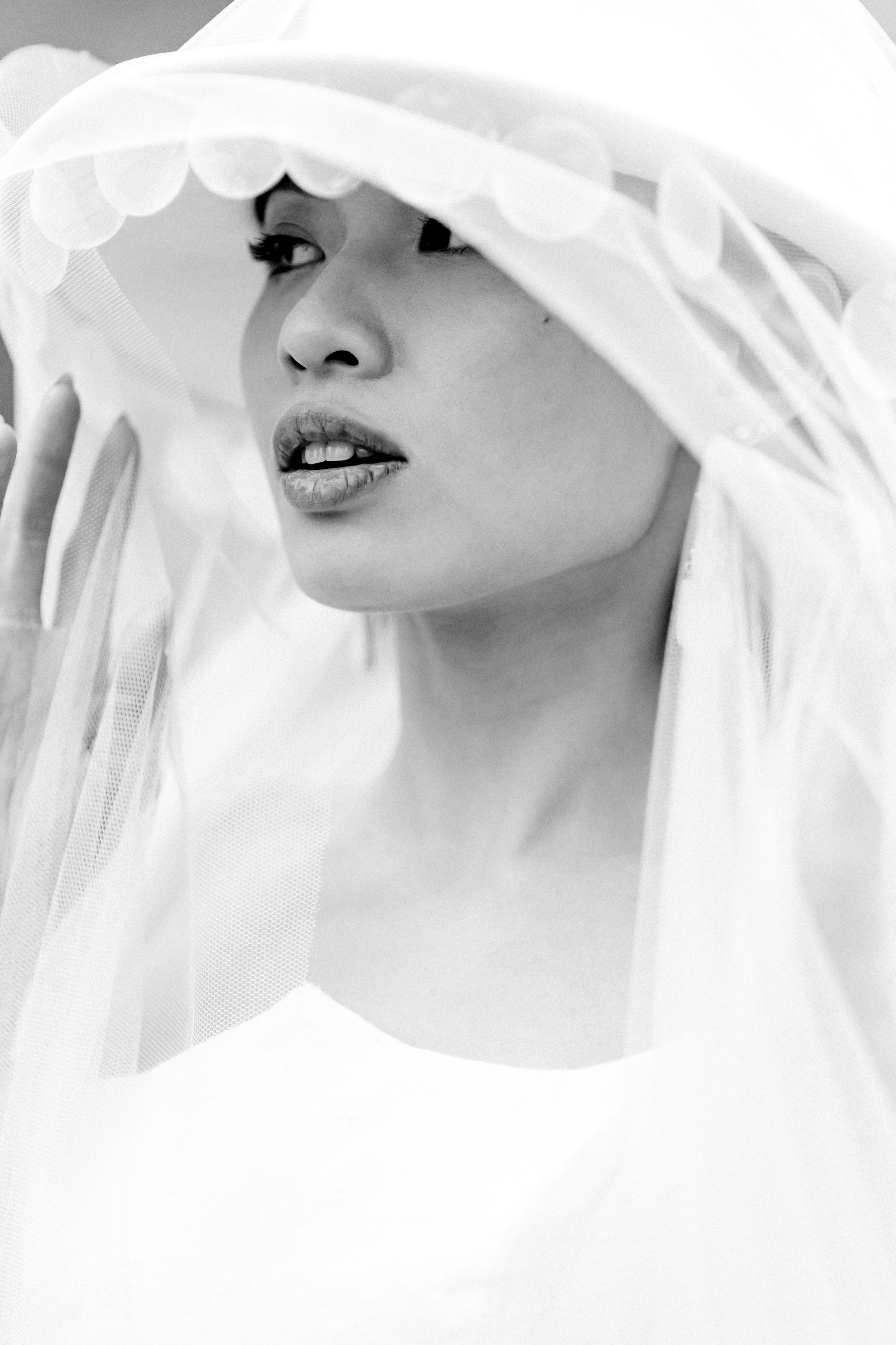 A bride in a lace wedding dress gently holds.
