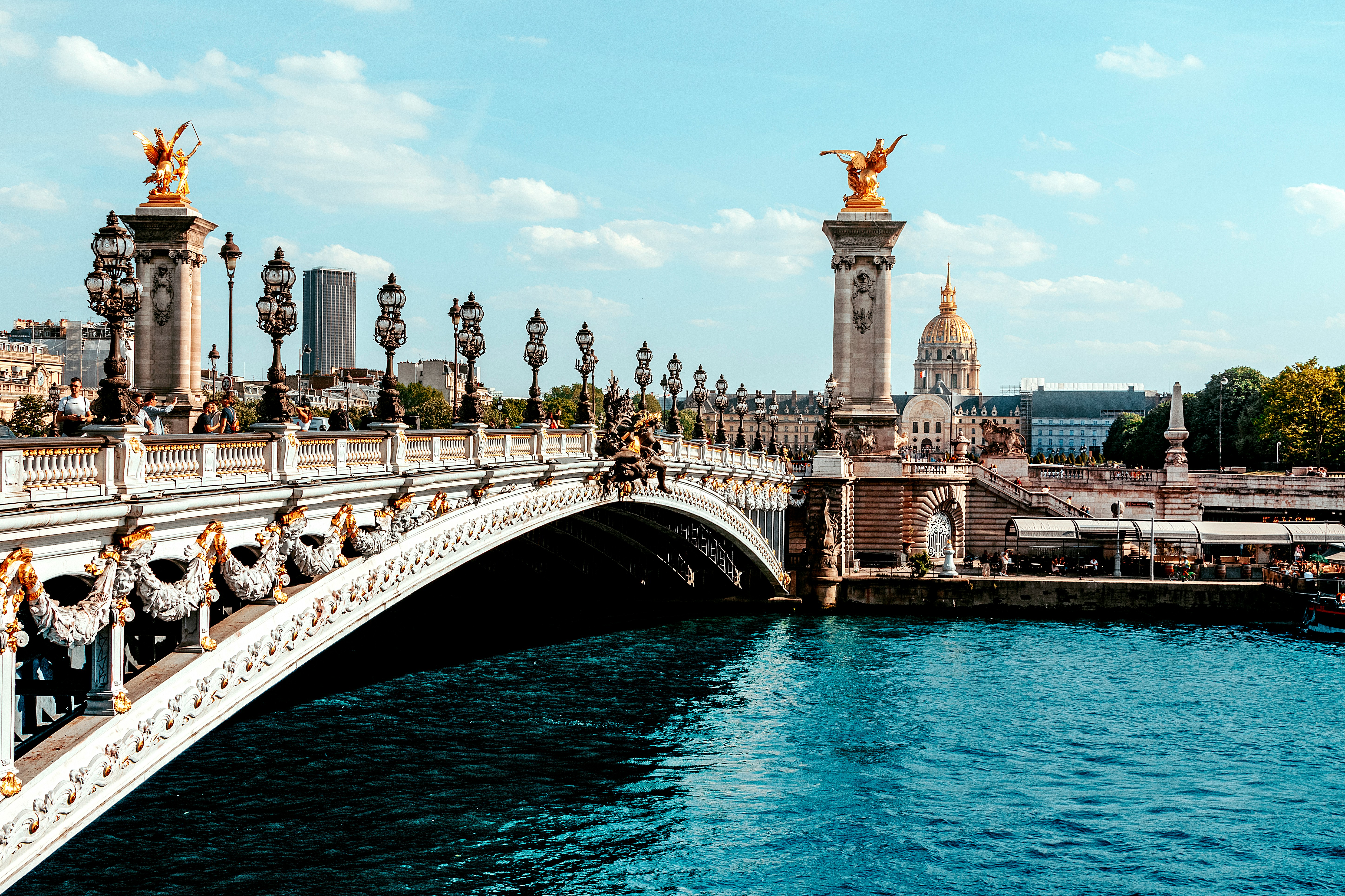 a bridge over a body of water with a statue on top