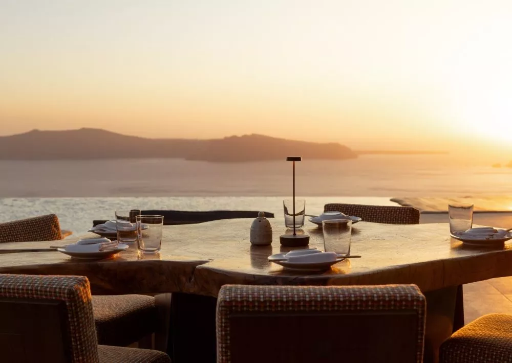 Festlich gedeckter Tisch am Meer bei Sonnenuntergang