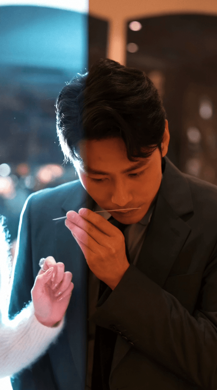 Bride sitting on ground against wall, groom standing nearby