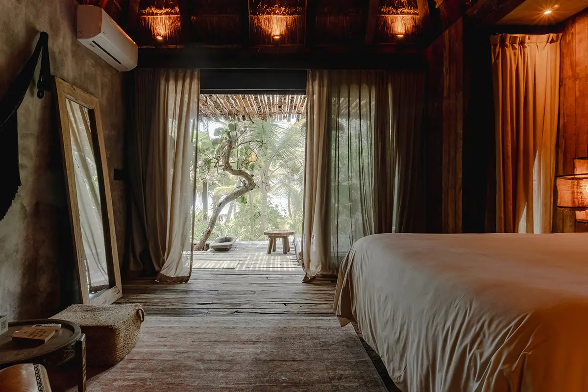 Standard Room en Nômade Tulum, con cama, almohadas y armario.