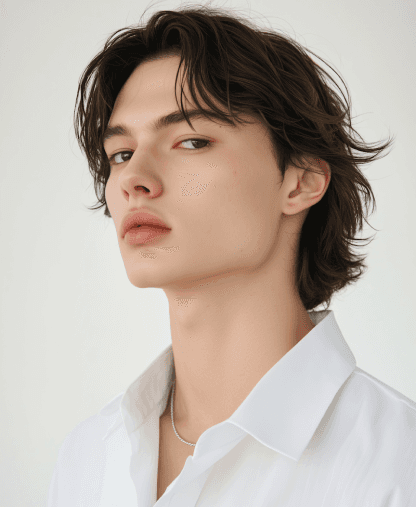 Headshot of a young woman with brown hair styled in a low ponytail and bangs. She's wearing a black shirt and hoop earrings.