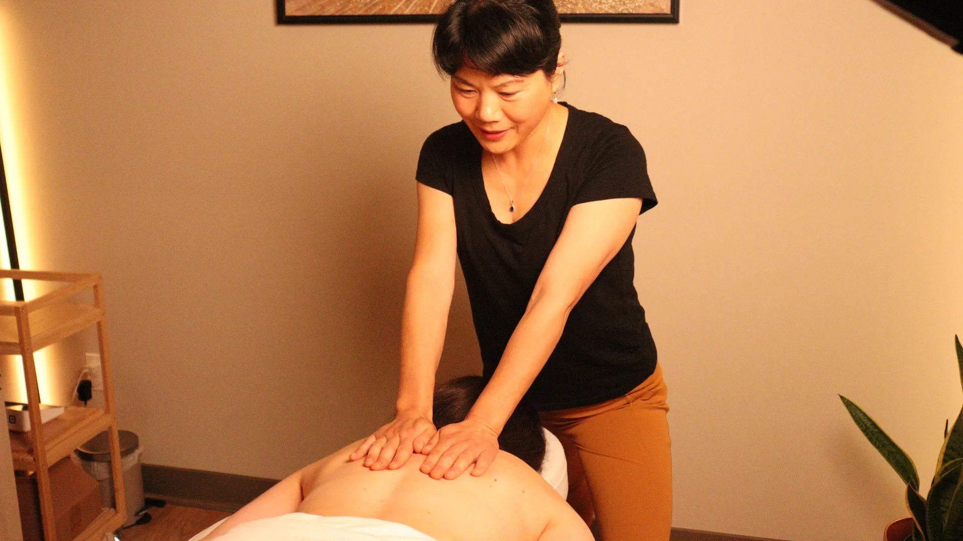 Practitioner at Zen Quest Wellness massaging a patient's upper back.