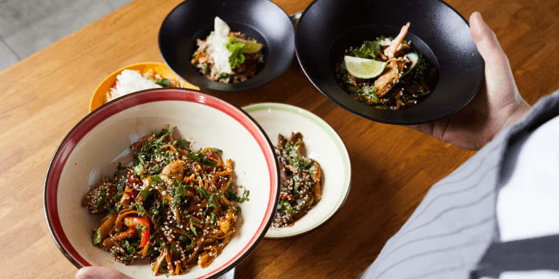 Seorang pekerja F&B sedang menyajikan makanan