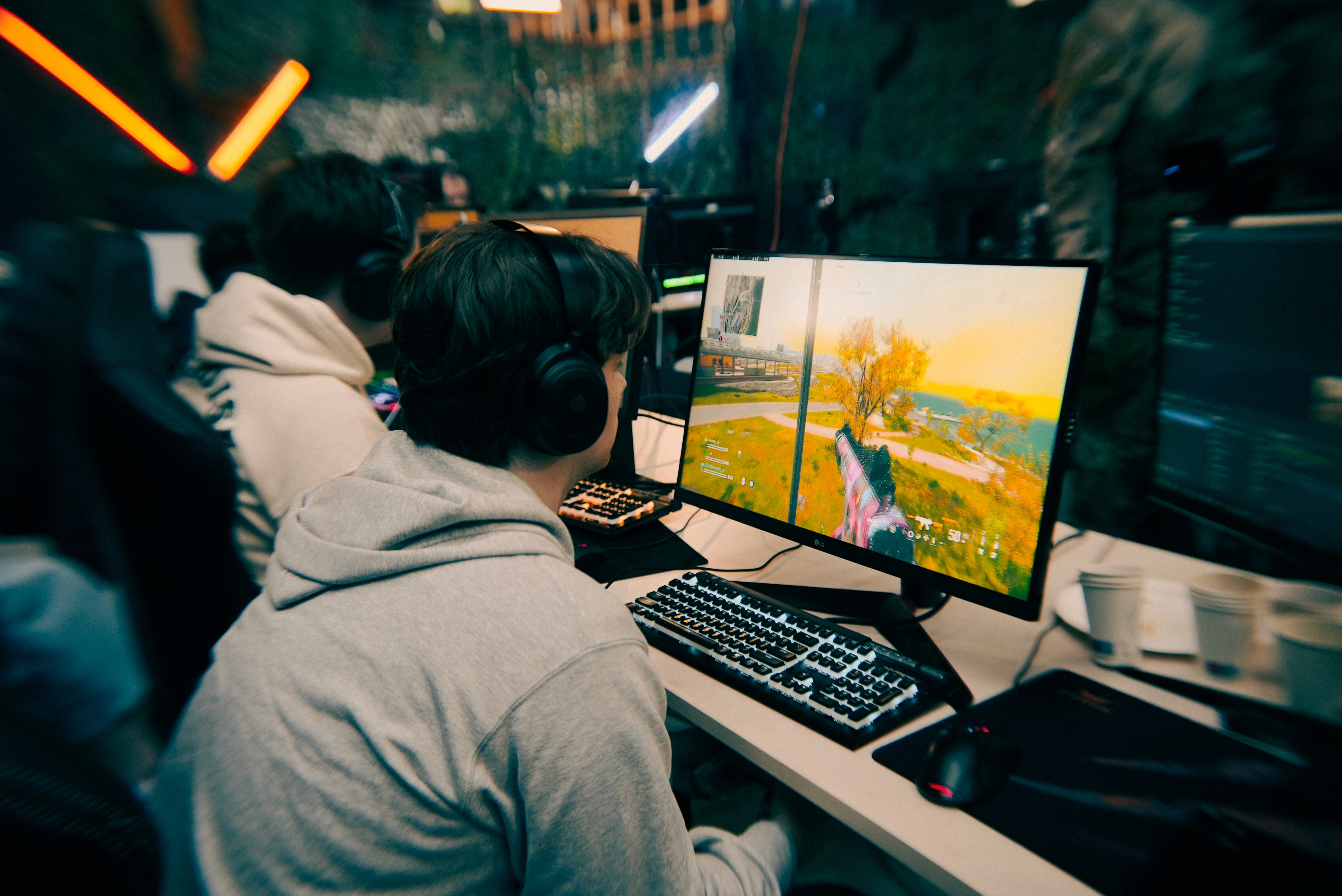 Persoon met headset in een studio tijdens een livestream-opname, zittend achter een mengpaneel met microfoon en apparatuur