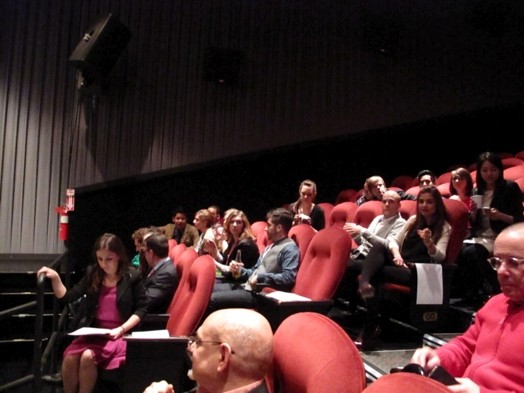 people sitting on red chairs in the amphitheater