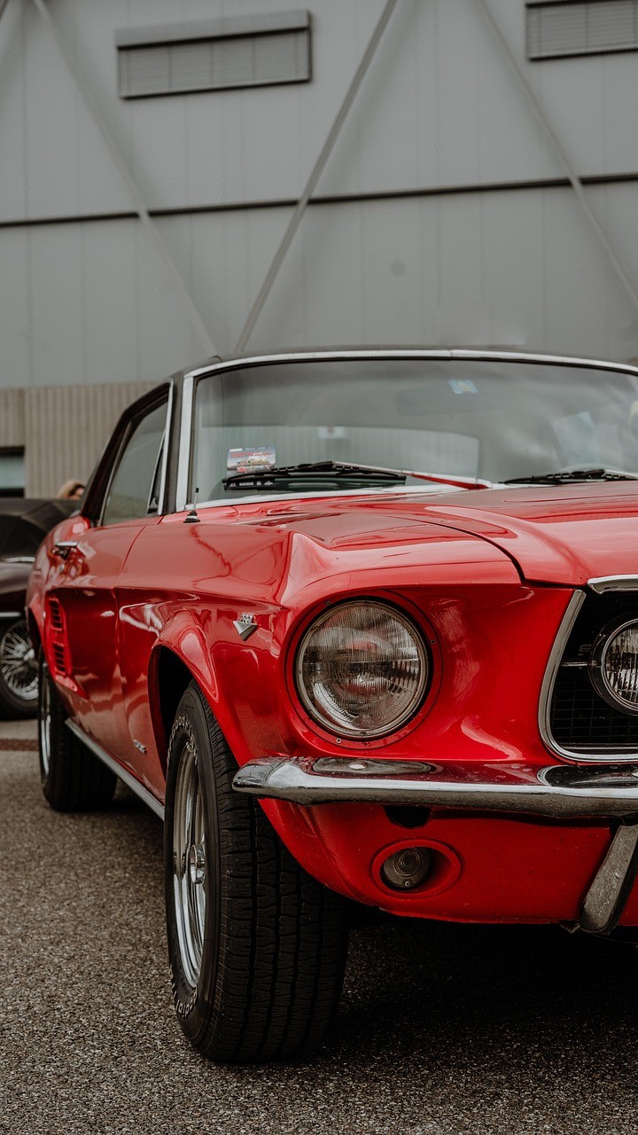 Modern kitchen with a wooden dining table, white chairs, and a hanging light fixture above.