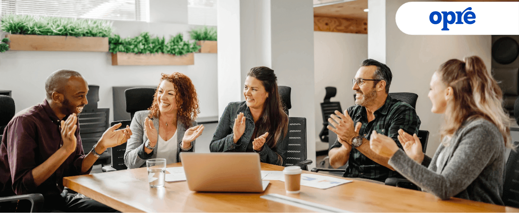 A team of people in a conference room applauding