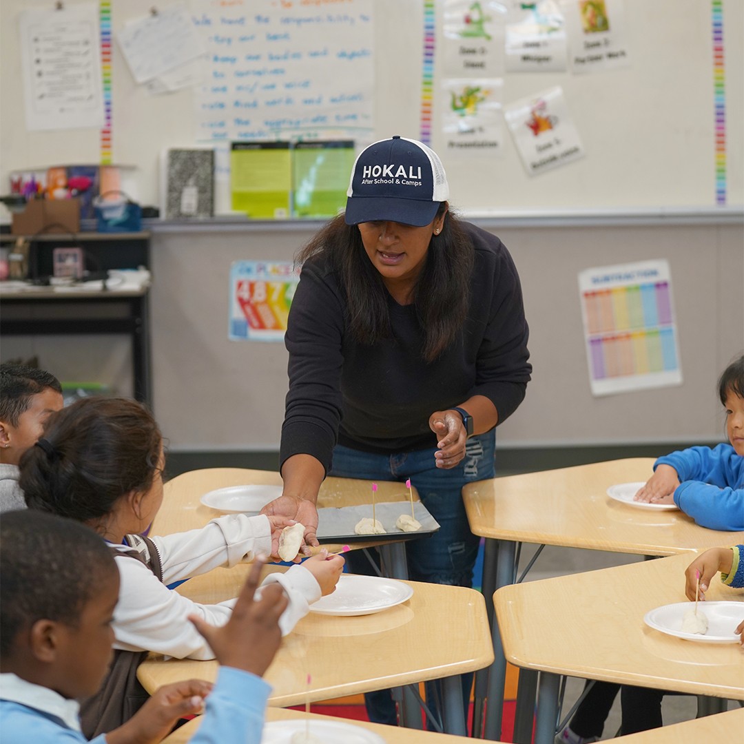 HOKALI instructor guiding students through a hands-on cooking enrichment activity in the classroom