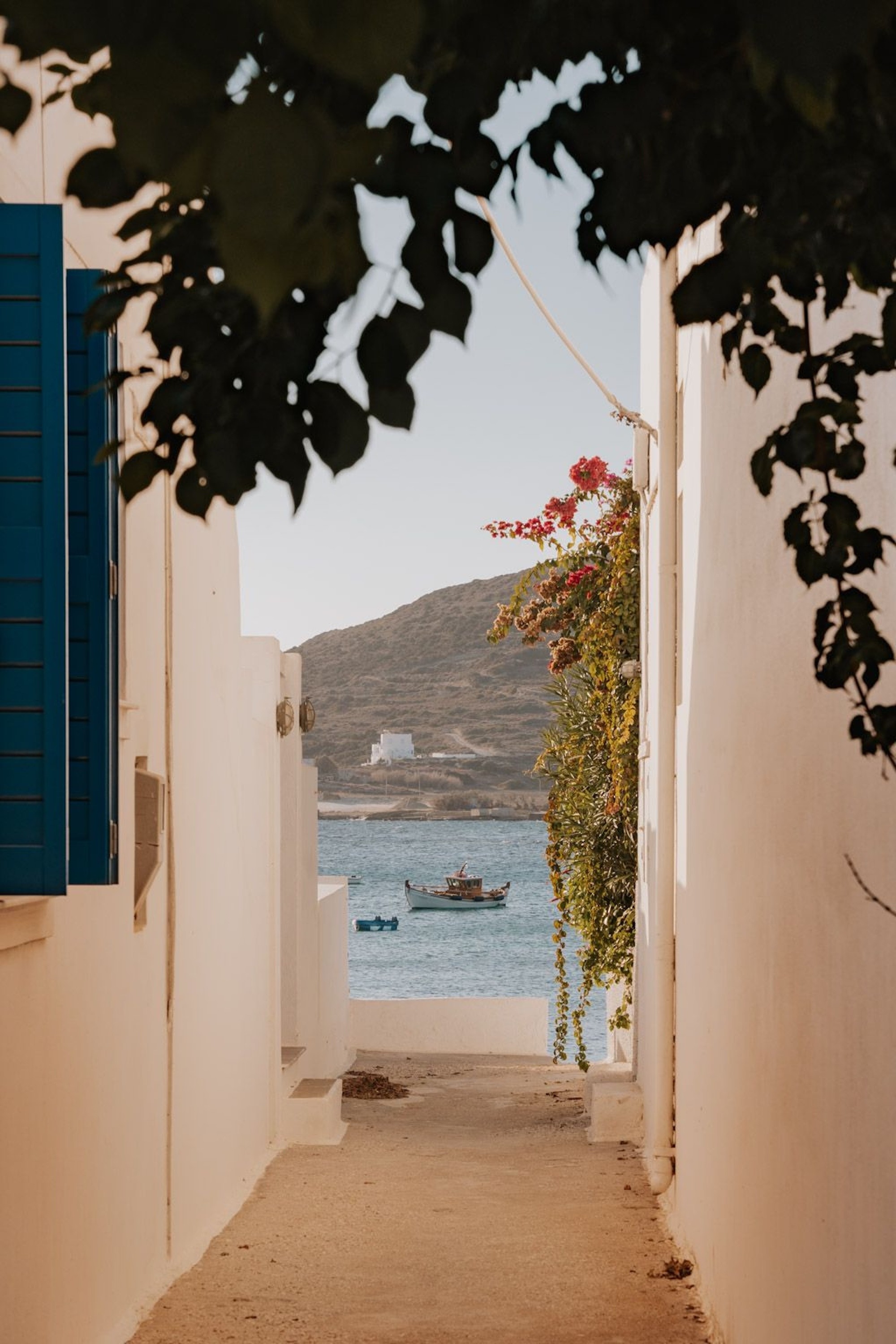 Whitewahed building and the sea at the end of the view.