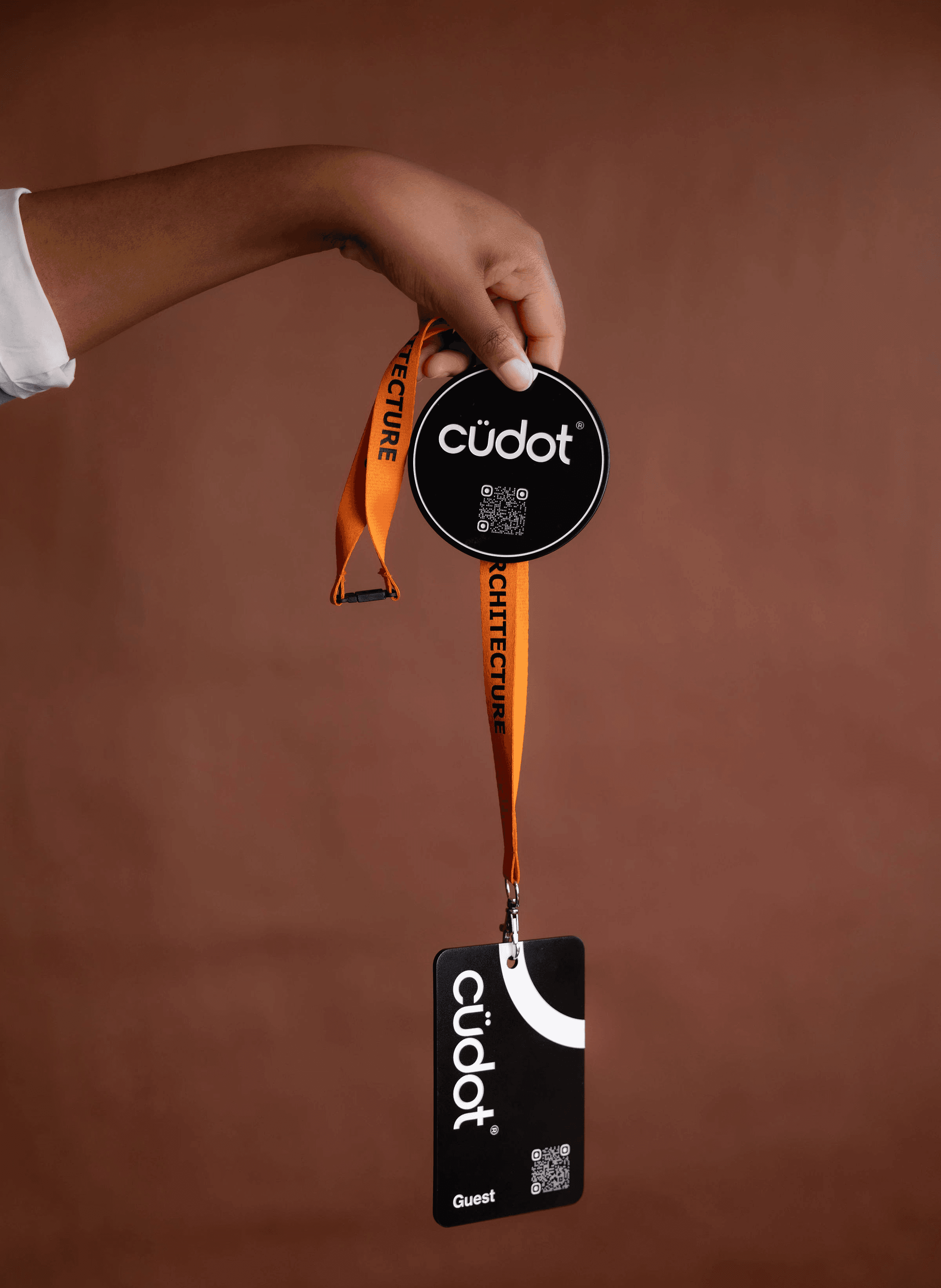 Image shows person holding a cudot scan coaster and lanyard.