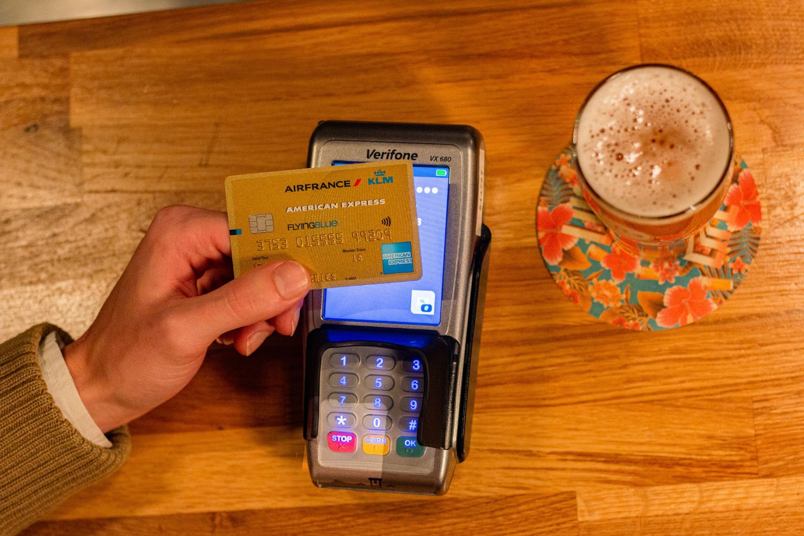 Someone holding an Air France credit card on top of a card machine 