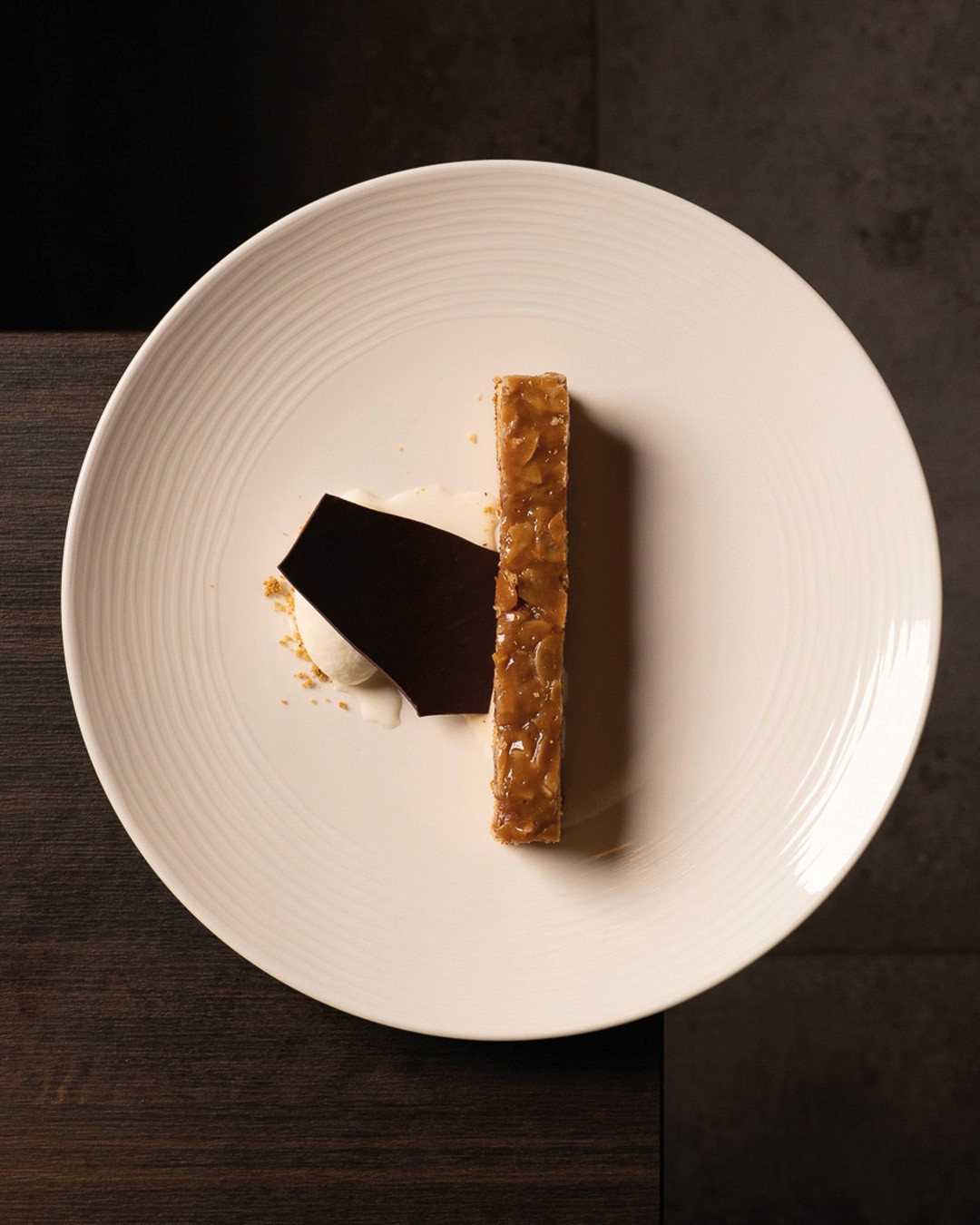 „Knusprige Karamell-Schnitte mit dunkler Schokoladengarnitur und Vanillecreme – elegantes Dessert aus der Patisserie des Ristorante Giuseppe Gentile.“