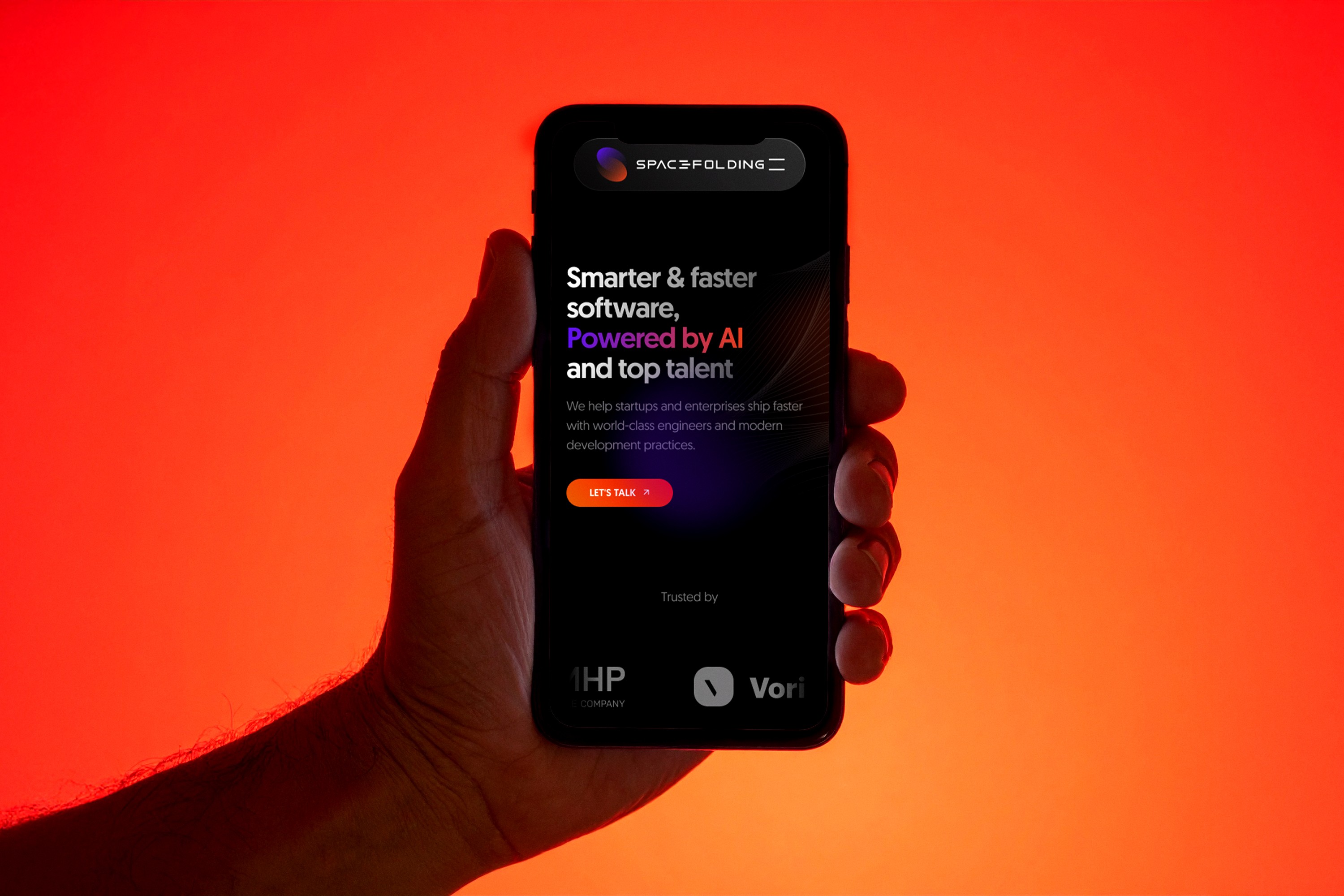 Photo showing A person holds a smartphone showcasing Spacefolding AI software on screen against red background.