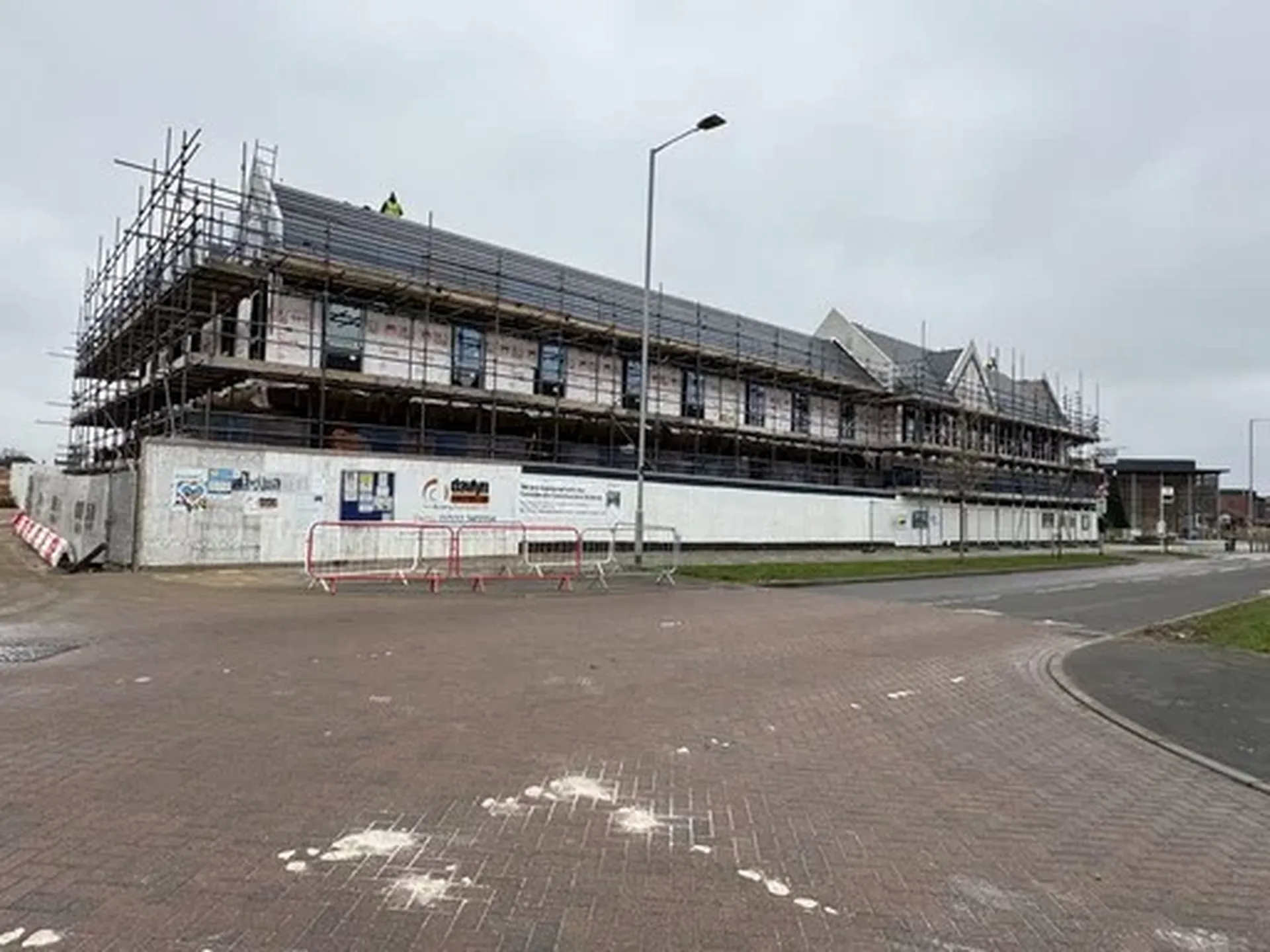Scaffolder assembling temporary roof trusses on a residential site