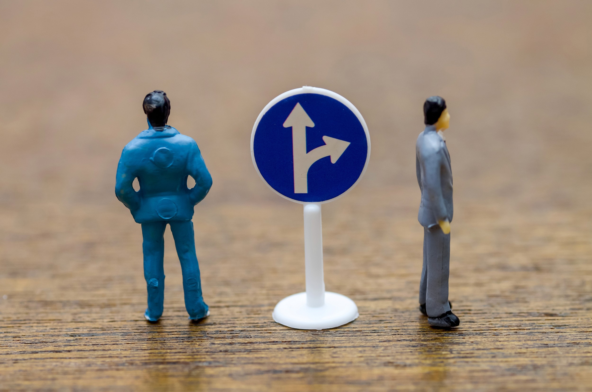 Career Decision Concept: Miniature Figures Choosing Between Two Paths