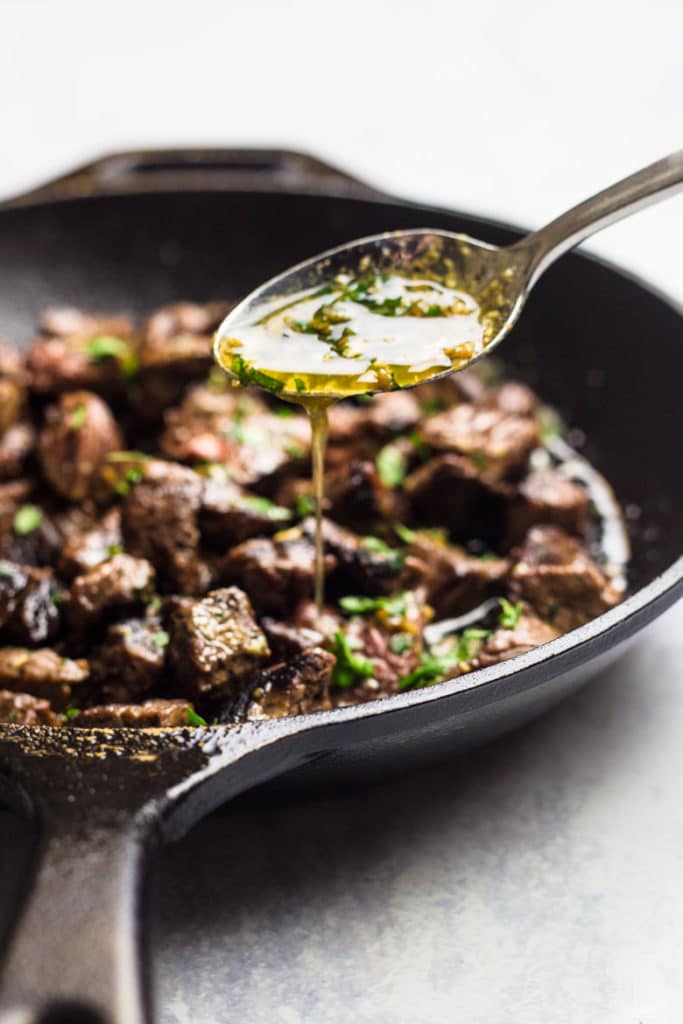 Freshly baked Margherita pizza with melted cheese, tomato sauce, and basil leaves, held by a person’s hand.